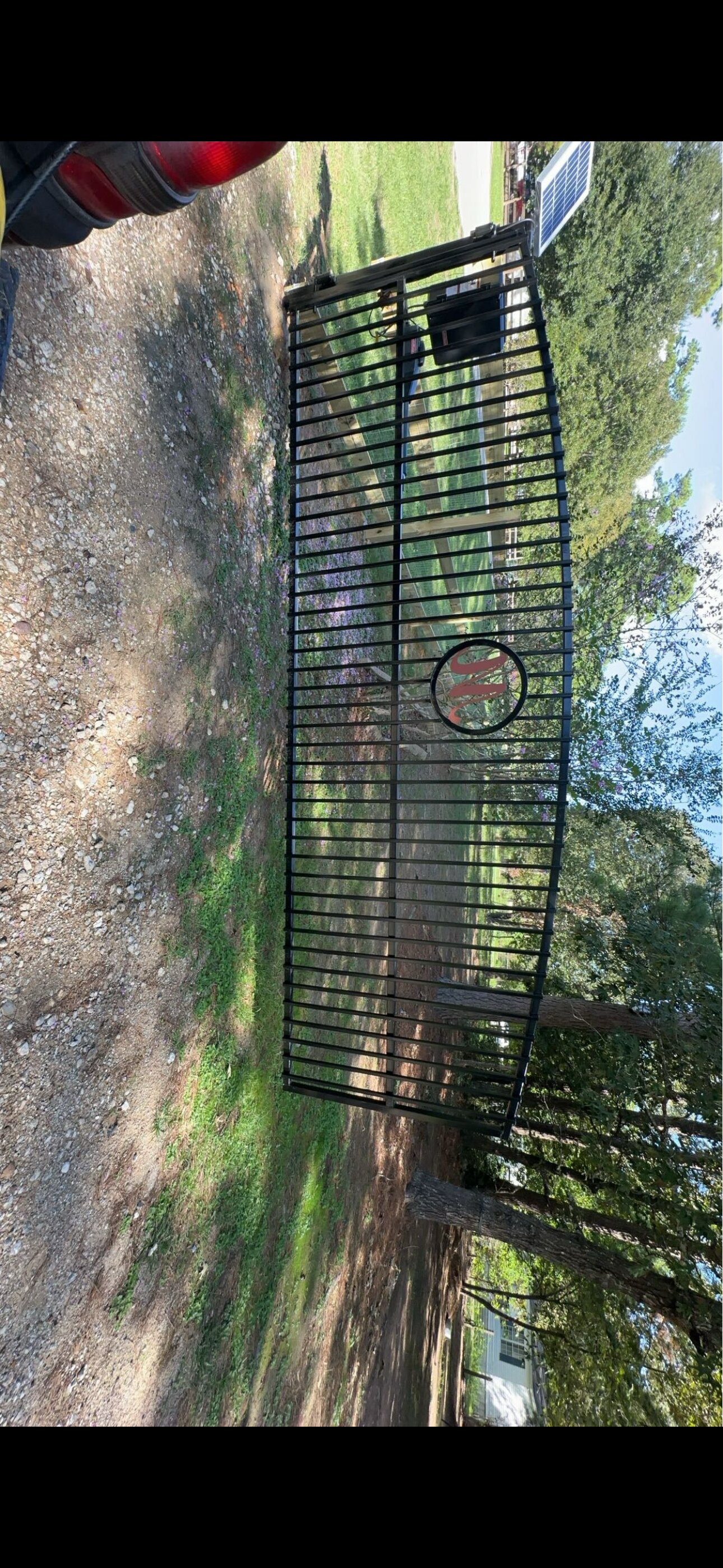 Custom driveway gate with arched top and emblem
